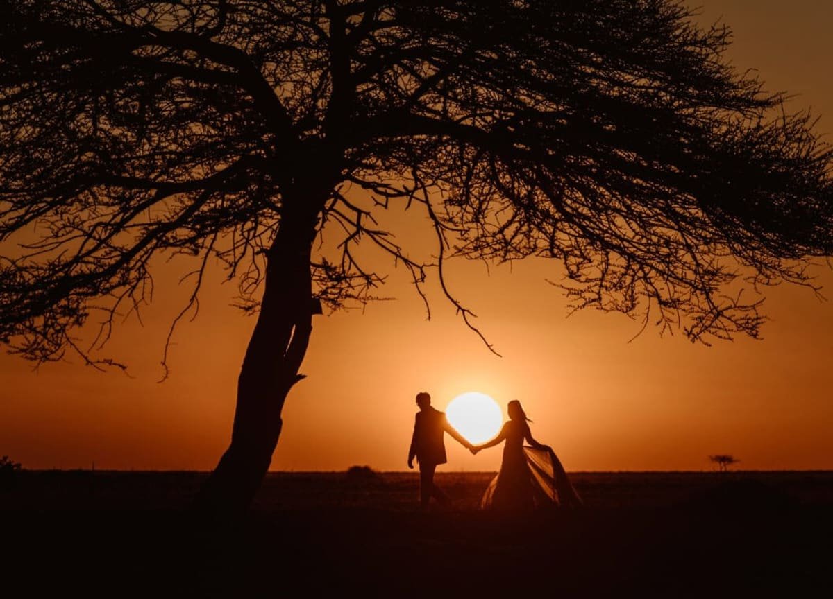 Sundowners for two — the pride three hills away — Masai Mara, Kenya